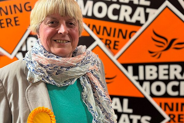 Liberal Democrat Candidate Jackie Pearcey in front of a sea of Lib Dem diamonds